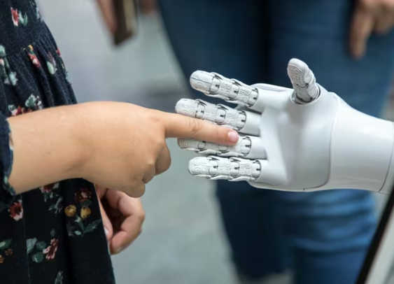 Recuso de niño tocando la mano de un robot