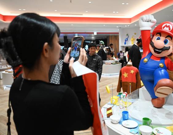 AFP | Una mujer le toma foto a la imagen de Super Mario de Nintendo.