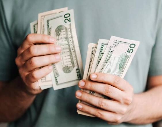 PEXELS | Una personas con dinero en sus manos.