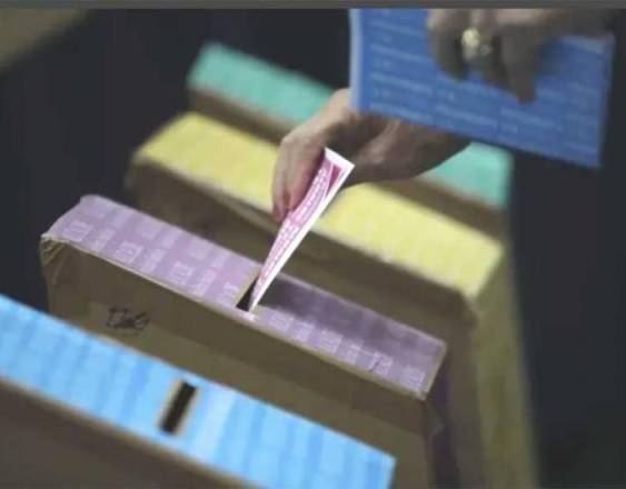 ML | Una persona con una papeleta en mano, ejerciendo su voto en una urna del Tribunal Electoral.