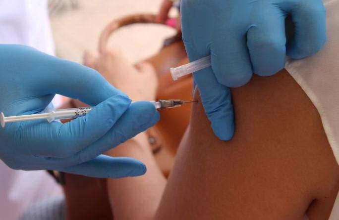 ML | Una enfermera coloca una vacuna en el brazo.