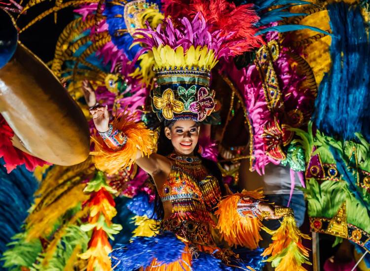 Foto cortesía ATP | Una reina de Carnaval se pasea ataviada con un vestido tradicional de plumas de diferentes colores.