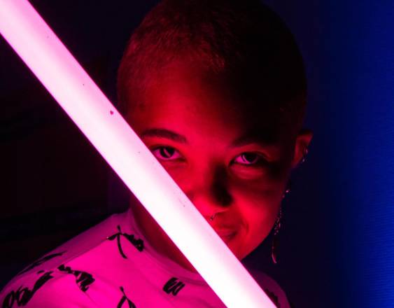 Una niña sostiene una espada de juguete con luz láser.