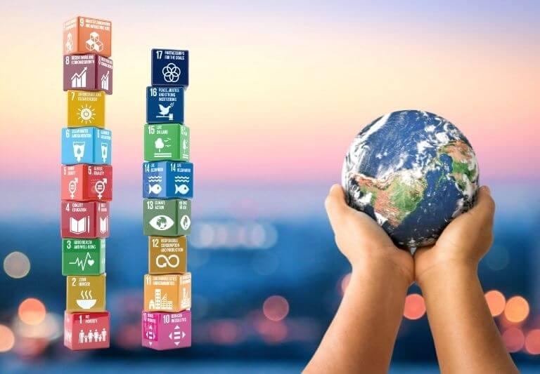 ML | Imagen ilustrativa de la Organización de las Naciones Unidas que muestra los iconos que representas los objetivos y un planeta.