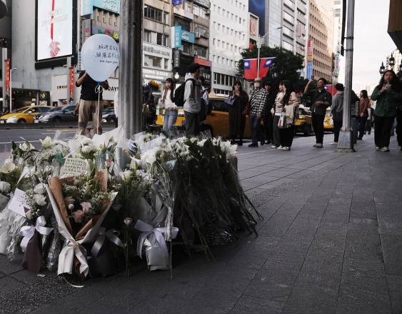 Flores y notas del público se colocan para las víctimas del ataque en el metro frente a un centro comercial en Taipéi el 20 de diciembre de 2025.
