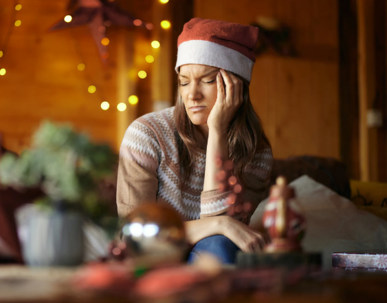 ML | Una mujer sentada en el sofá de su hogar estresada por las compras de fin de año.
