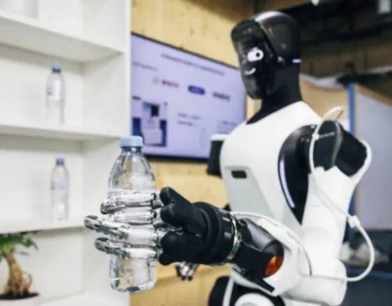 Portaltic/EP | Robot humanoide sostiene en su mano una botella de plástico.