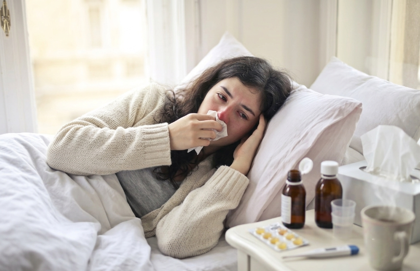 Generada con IA | Una mujer acostada en la cama con resfriado y Tomando Medicinas.