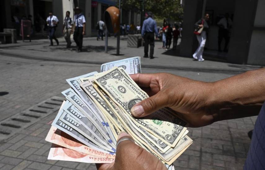 AFP | Un hombre trabaja en la calle cambiando dólares por lempiras (moneda oficial hondureña).