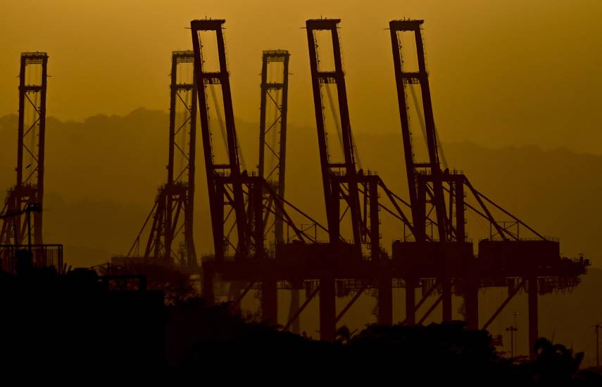 AFP | Las siluetas de las grúas portacontenedores en el Puerto de Balboa se ven al atardecer a la entrada del Canal de Panamá en la Ciudad de Panamá el 24 de febrero de 2026.