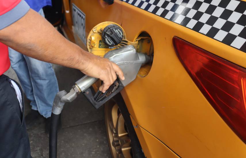 ML | Un taxista cargando su auto de combustible.