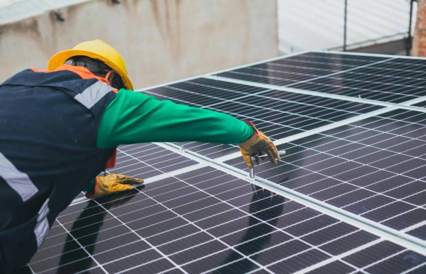 ML | Un hombre en medio de su jornada laboral colocando paneles solares en una empresa que ha decidido apostar completamente a la energía limpia.