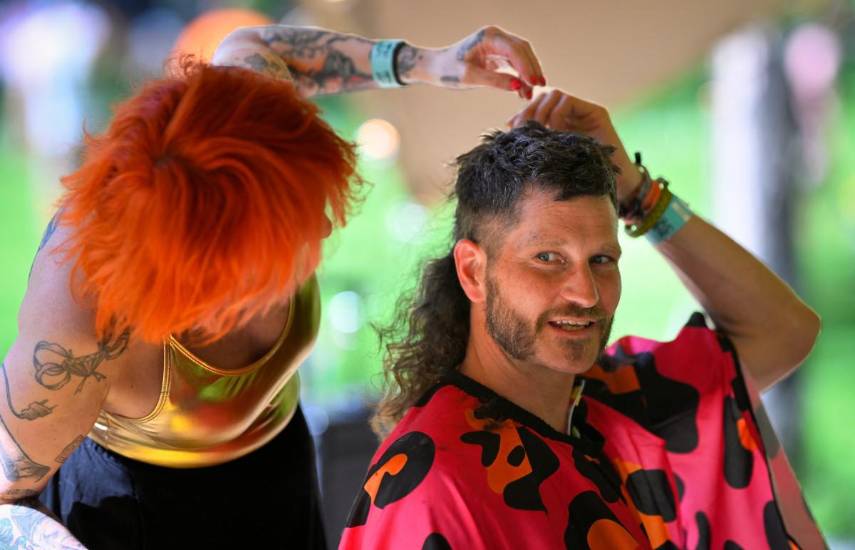 $!A man has his hair cut during the annual European Mullet Cup in Audregnies, southern Belgium, on May 23, 2026. This year's European championship is the fourth to be held since a group of enthusiasts in Belgian borrowed the idea of a staging a competition from Australia. Wannabe champions for this edition had come from as far a field as France, Spain and England. (Photo by JOHN THYS / AFP)