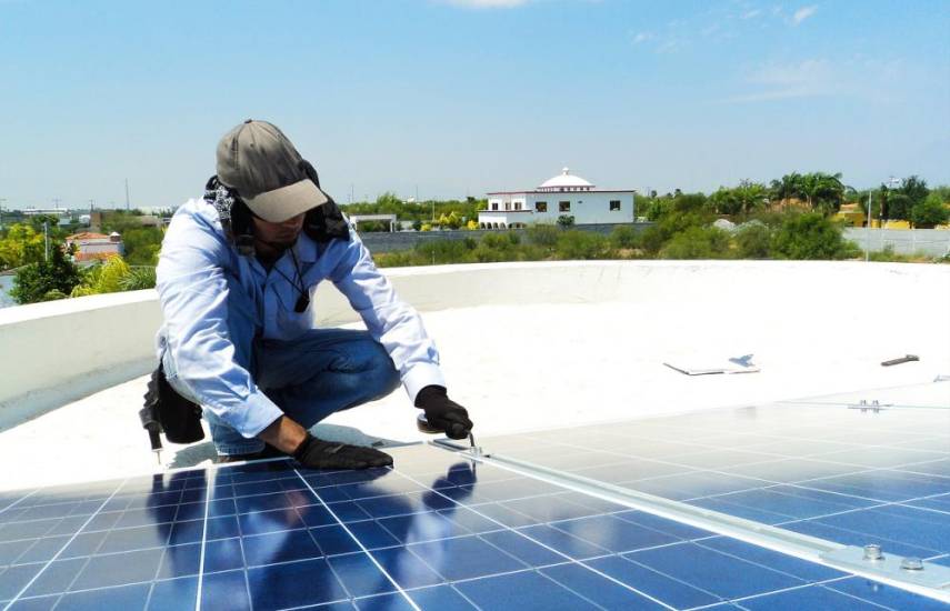 PIXABAY | Un hombre instalan un sistema de panel solar.