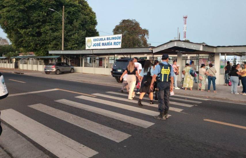 ATTT | Una unidad del tránsito ayudando a las personas a cruzar la calle frente a una escuela.