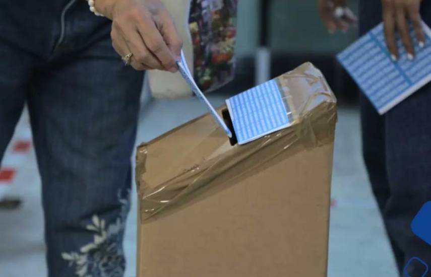 ML | Una persona emitiendo su voto en una urna.