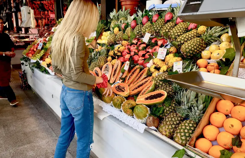 Pexels | Una mujer visitando el área de mercado en la feria y comprando papaya.