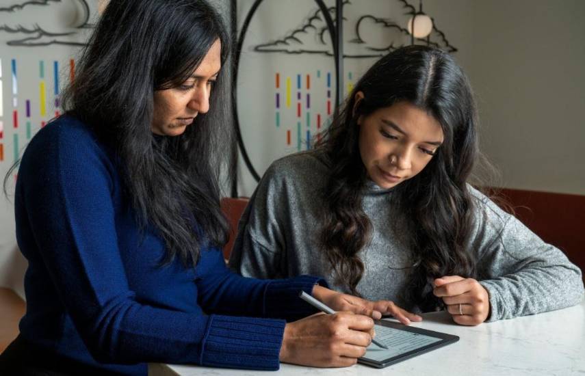 Dos mujeres revisando un texto en un lector Kindle