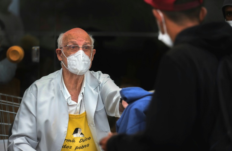 El sacerdote católico Júlio Lancellotti entrega prendas de vestir a indigentes en un centro comunitario de Sao Paulo, el 30 de mayo de 2022