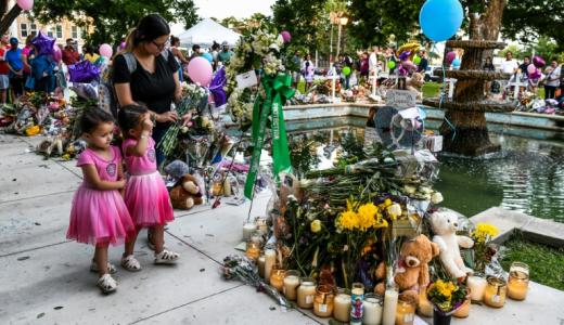 Una madre y sus dos hijas depositan flores en memoria de las víctimas de la escuela de Uvalde el 27 de mayo de 2022 a las puertas del tribunal de la localidad texana (EEUU)
