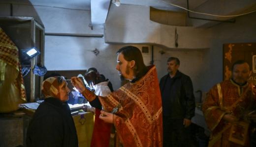 Unos sacerodtes ortodoxos rezan con unos fieles en el sótano de una iglesia en Lysychansk, en el este de Ucrania, en la región del Donbás, el 20 de mayo de 2022