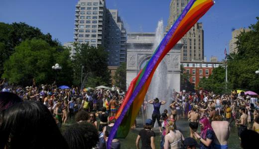 La gente se refresca en la fuente del Washington Square Park en Nueva York el 26 de junio de 2022 al término del desfile del Orgullo