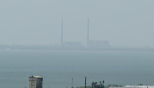 La silueta de la central nuclear de Zaporiyia se perfila entre la bruma al otro lado del río Dniéper, en una imagen tomada desde Vyschetarasivka, el 13 de agosto de 2022 al sur de Ucrania