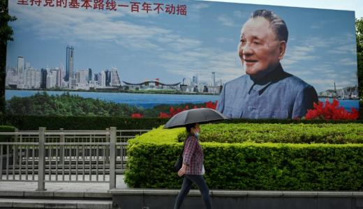 Una mujer pasa por delante de un cartel del líder chino Deng Xiaoping el 13 de julio de 2022 en la ciudad china de Shenzhen