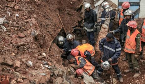 Los bomberos buscan supervivientes después del derrumbe de un aparcamiento sobre unas casas en el barrio de Ankadifotsy, en Antananarivo, el 24 de enero de 2022 a consecuencia de las intensas lluvias