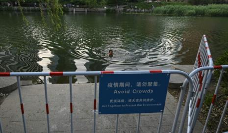 Un hombre nada en el río Liangma en Pekín el 20 de mayo de 2022