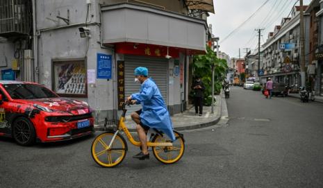 Un hombre con equipo de protección circula en bicicleta en Shanghái (China), el 21 de junio de 2022